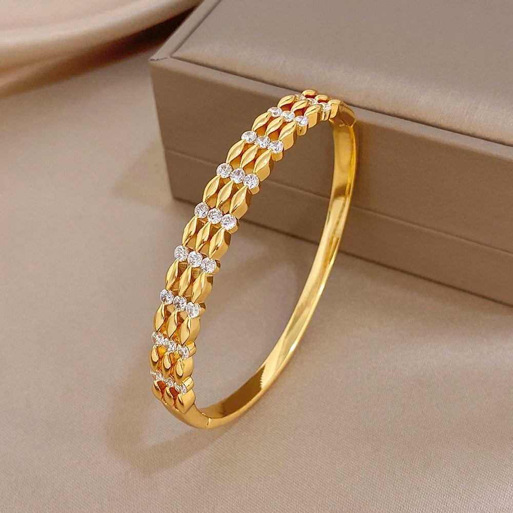 Gold cuff bangle side view with textured bar links and round crystal stone accents