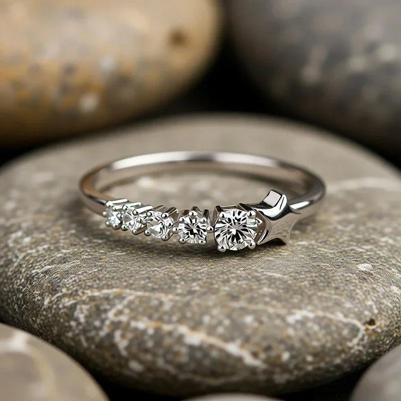 Silver-tone CZ ring on a pebble, featuring star top and round center CZ stone