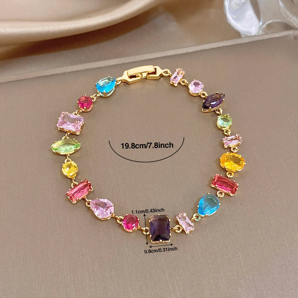 Gold-tone geometric zirconia link bracelet, multicolor stones; includes size markings.
