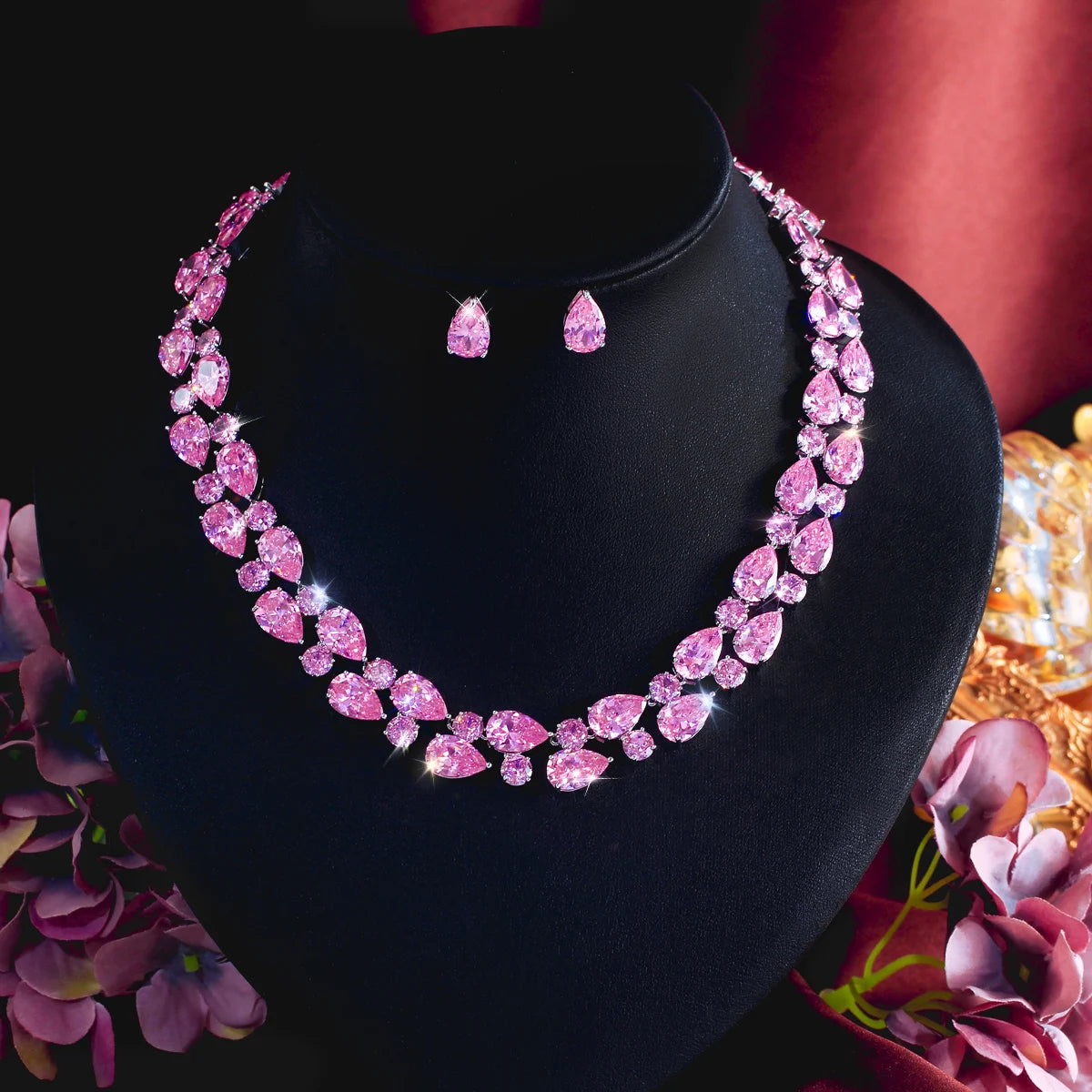 Pink teardrop rhinestone necklace and drop earrings set on black jewelry bust