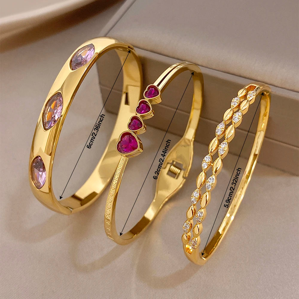 Gold tone heart charm bangles with pink and purple zircon stones, stackable cuffs