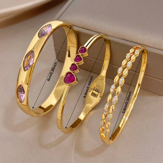 Gold tone heart charm bangles with pink and purple zircon stones, stackable cuffs