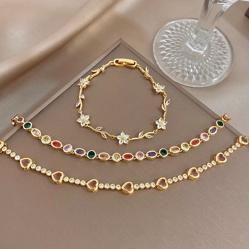 Gold-tone chain bracelet set with rainbow beads and small white flower center charms