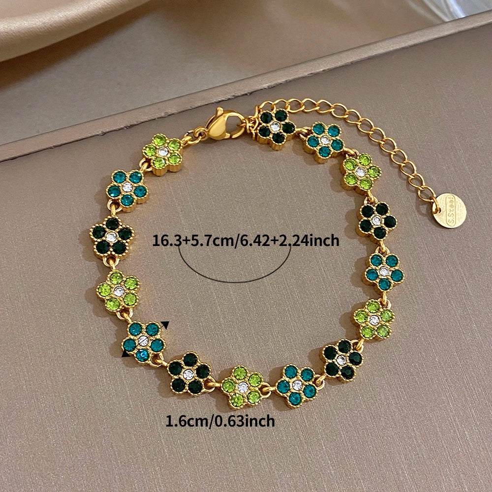 Gold-tone flower zircon bead bracelet with green and teal four-leaf clusters and extender chain
